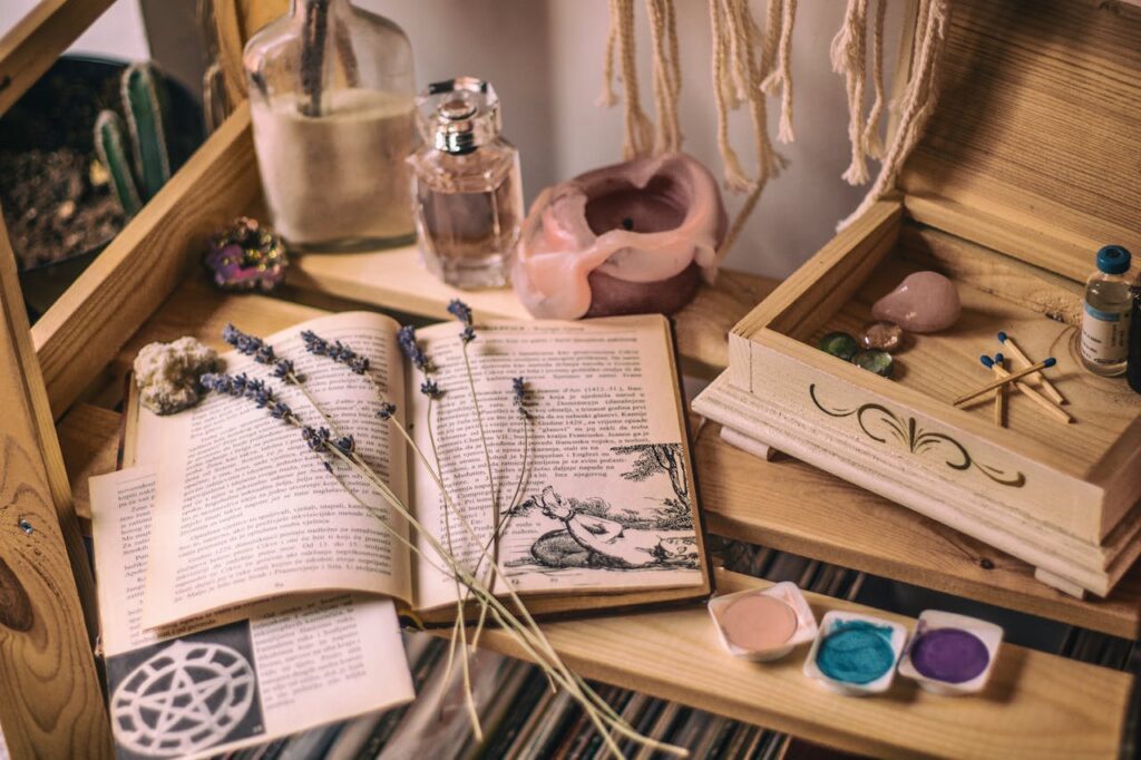 pexels-photo-2101704 Aesthetic setup with books, lavender, crystals, and candles on a wooden shelf.