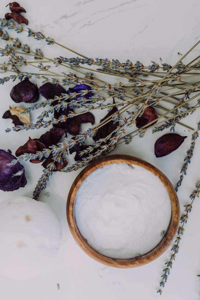 Flat lay of natural skincare products with lavender and floral elements for relaxation and spa themes.